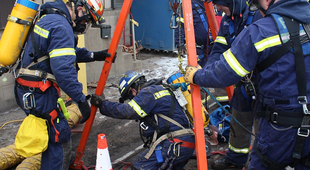 Rescuer lowering into the scale pit under a rail system