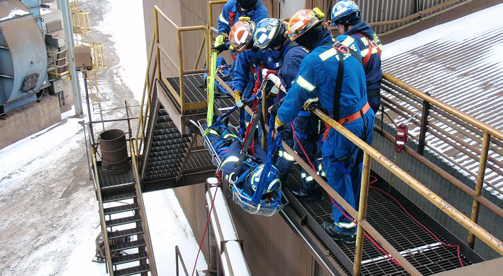 Rescue team practicing lowering a basket with obstructions in the way of the descent